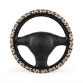 Black brown cow print steering wheel cover, on a steering wheel