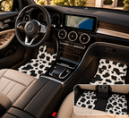 Black white cow print car mats shown in a car interior