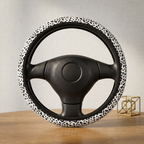 White leopard print steering wheel cover on a wooden table